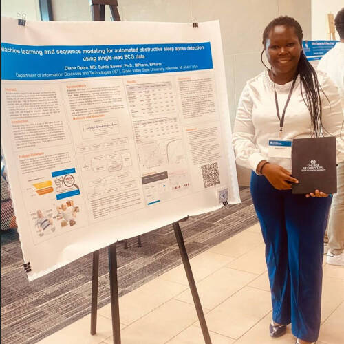 Diane Opiyo stands with her award winning poster at Tech Week Grand Rapids 2026